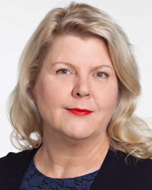 Kasvokuvassa vaaleatukkainen, vakavailmeinen tummaan asuun pukeutunut nainen.