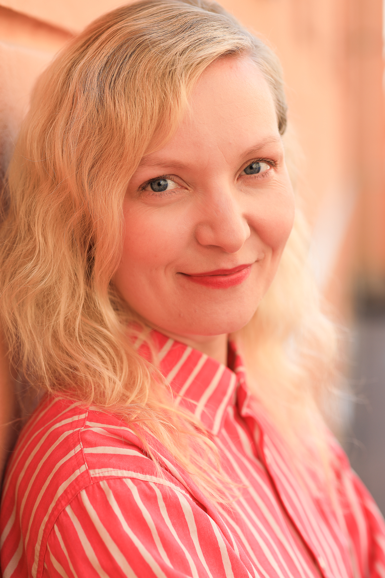 Vaaleatukkainen, avohiuksinen nuorehko nainen väljästi rajatussa kasvokuvassa.